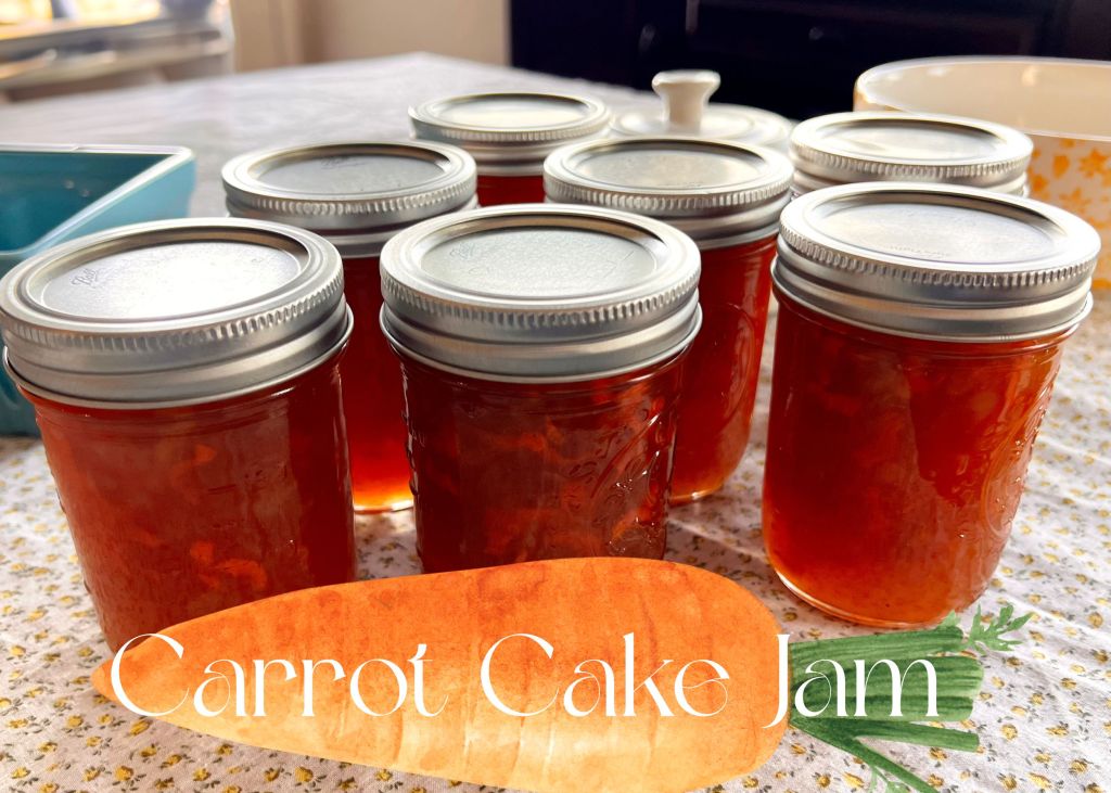 Homemade carrot cake jam in a glass jar with fresh carrots on a white vintage table cloth with yellow flowers.